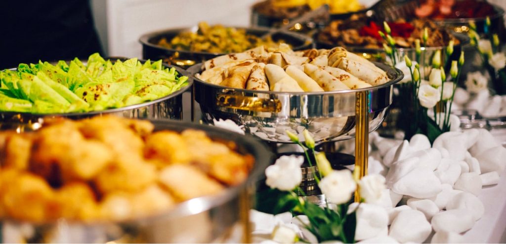 Food in multiple trays in a buffet style setup.
